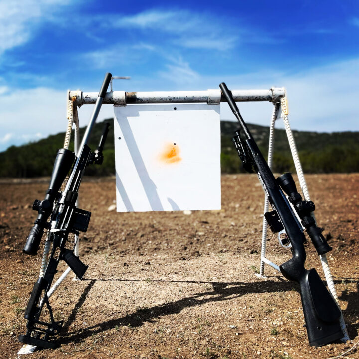 A shooting range with guns and target on the ground.
